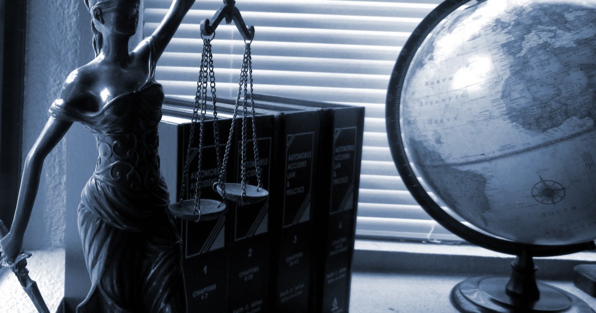 Thousands of School Booster Clubs Not in Compliance with Tax Laws Lady liberty and a globe on the desk of a legal professional