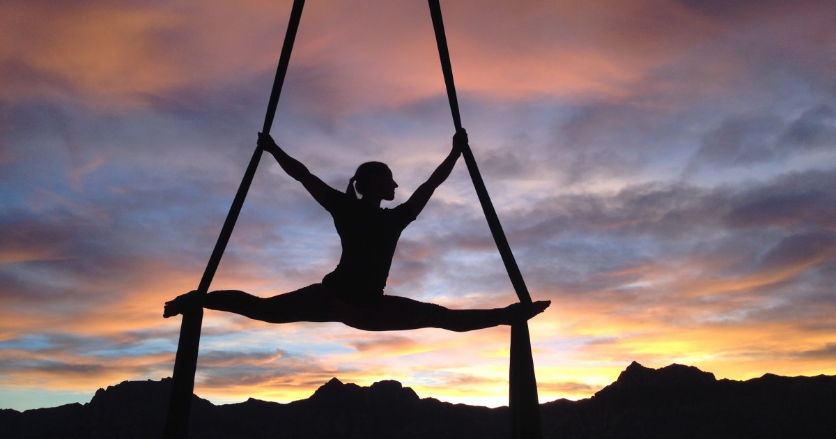 The Cost of Raising a Gymnast Aerial dancer hanging from ribbons while doing the splits