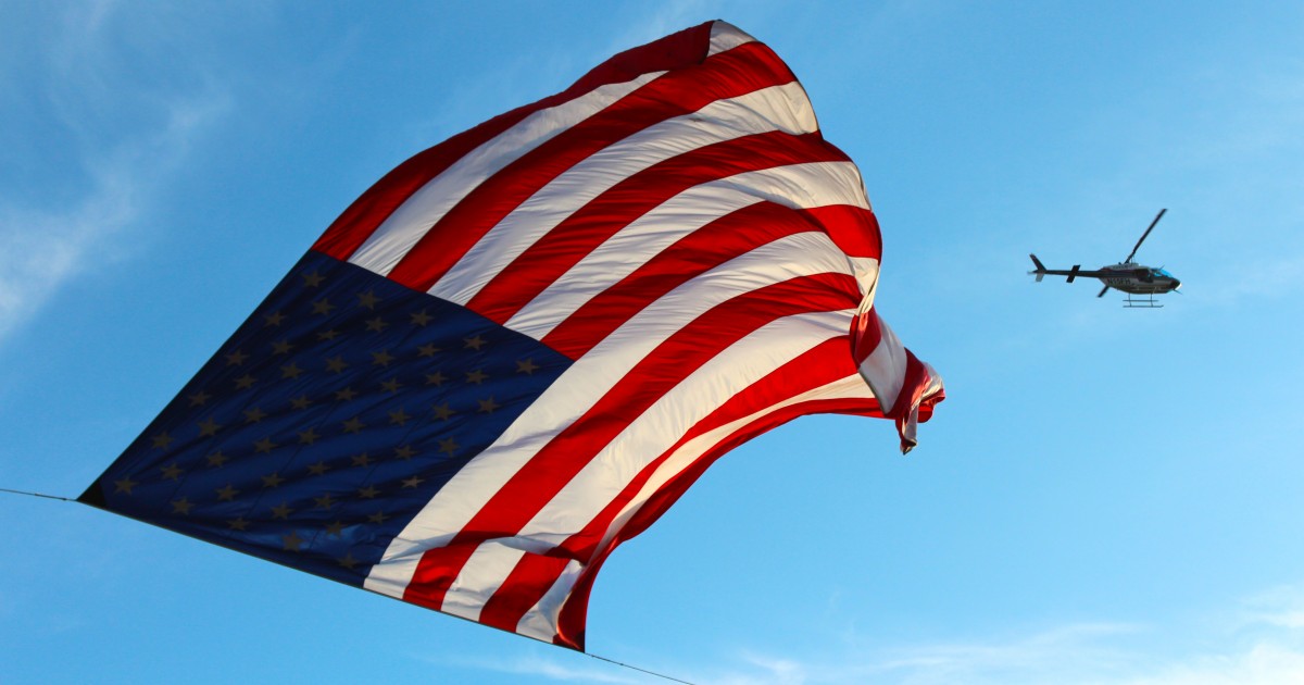 PBUSA Launches "Get Legal, Stay Legal" Campaign Large US flag and helicopter flying by in background