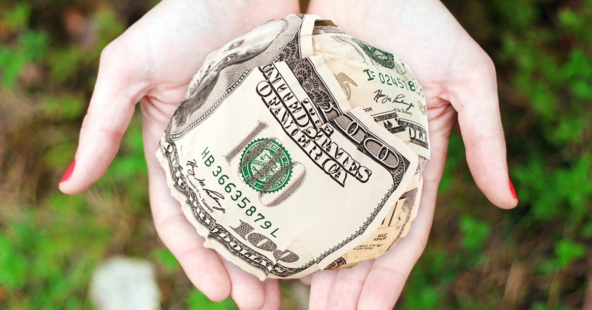 White Paper Details School Booster Club Fundraising Rules A beautifully spherical ball of money held in a woman's hands