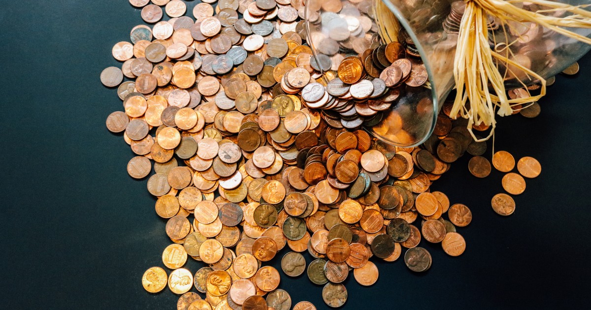 Sample Budget Glass vase of pennies dumped out into pile