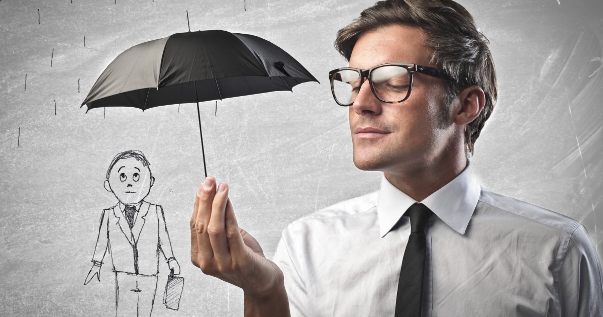 Risks and Insurance Man holding an amusingly small umbrella over a drawing of a man, illustrating insurance coverage